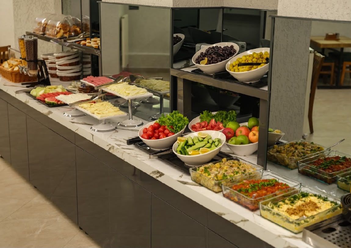 Un buffet proposant une variété d’aliments, notamment des salades, des fruits et des plats préparés.