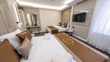 Een hotelkamer met een groot bed, een bureau, een televisie en een badkamer.