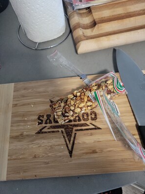 A wooden cutting board with a knife and a bag of mixed nuts on it. - Spacious 3-bedroom apartment with AC in beautiful Austin (Austin)