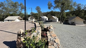 A campground with several tents and a paved parking area. - Moonshadow Flat Glamping Campground (Penn Valley)