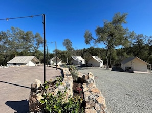 A campground with several tents and a paved parking area.
