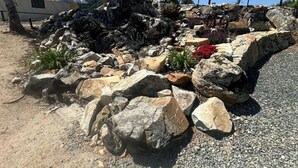 A gravel area with large rocks and a white tent-like structure in the background. - Moonshadow Flat Glamping Campground (Penn Valley)