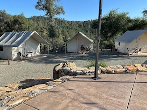 A campsite with two tents, a stone pathway, and a gravel area.