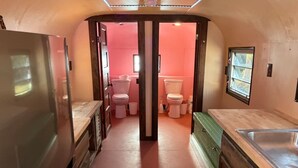 Cuina petita amb nevera, rentaplat i armaris de fusta.