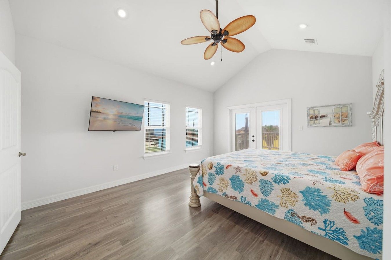 A bedroom with a bed, a ceiling fan, a painting, and a window with blinds.