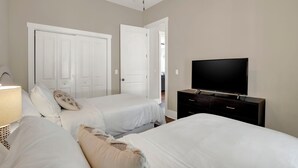 A bedroom with two beds, a TV, and a wardrobe. - New Thunderbolt Cottage on Harris Street Less than 4 Miles from Forsyth Park! (Savannah)