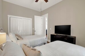 A bedroom with two beds, a TV, and a wardrobe.