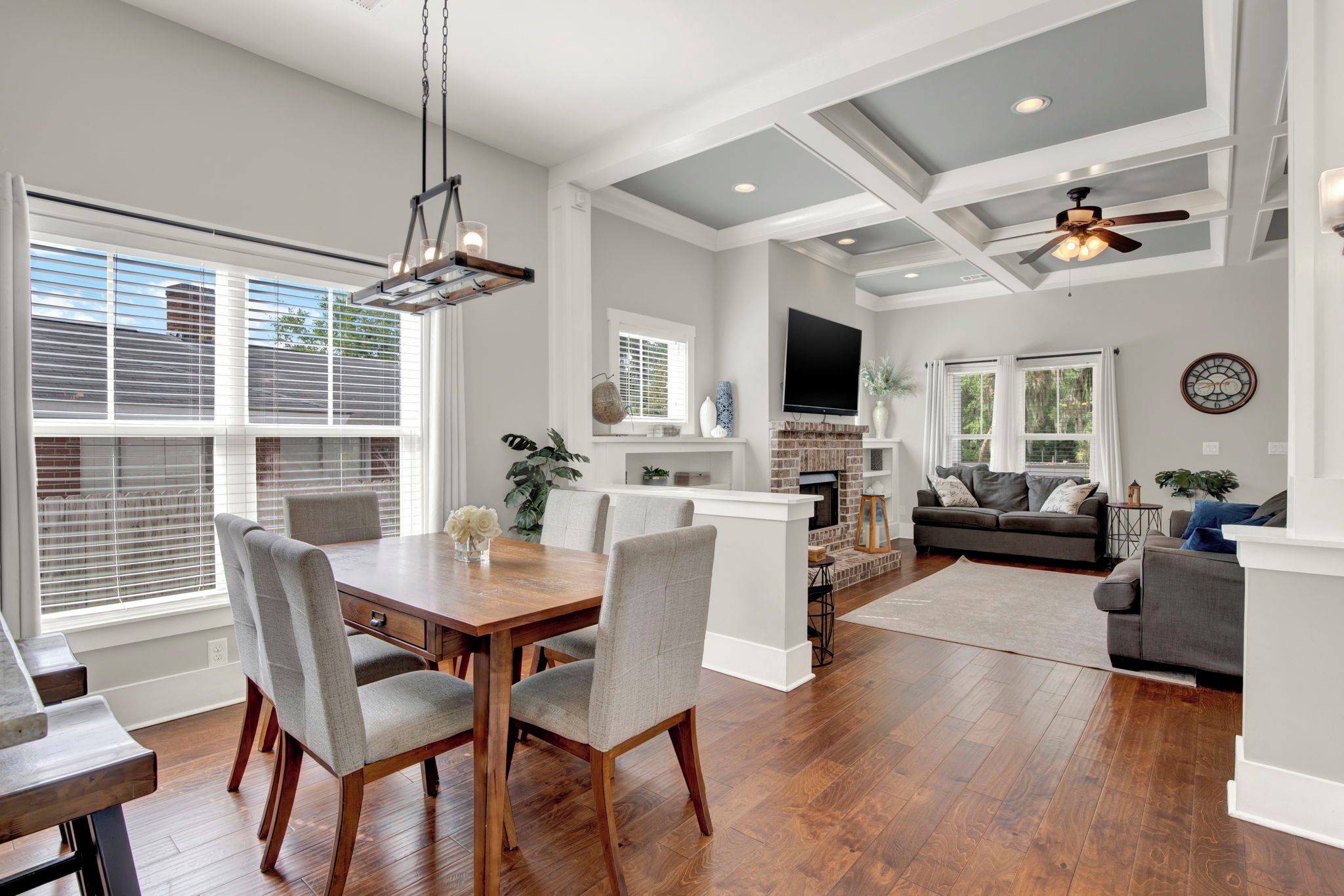 A spacious living area with a dining table, chairs, a sofa, and a television.