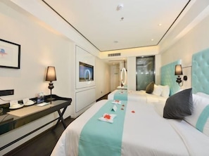 Una habitación de hotel con una cama, mesita de noche, lámpara y televisión.