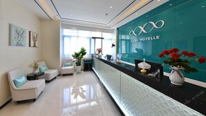 A reception area with a glass wall, a reception desk, and seating arrangements. - (Guangzhou)