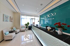 A reception area with a glass wall, a reception desk, and seating arrangements. - (Guangzhou)