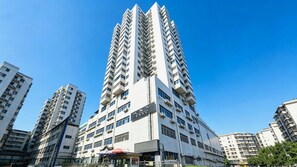 A high-rise building with multiple floors, large windows, and balconies. - Xana Hotelle (Guangzhou)