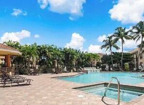 A pool area with lounge chairs and palm trees. - Paradise awaits! Straight shot to the beach! Close to all Naples has to offer! (Naples)