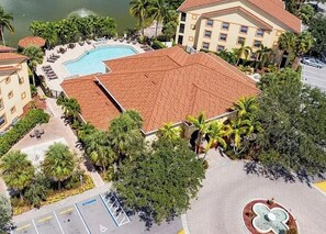 An aerial view of a hotel with a swimming pool, a parking area, and surrounding greenery. - Paradise awaits! Straight shot to the beach! Close to all Naples has to offer! (Naples)