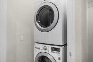 A stacked washer and dryer unit with a control panel and a digital display. - Cozy 4BDR house gated community, near Disney -2108 (Kissimmee)