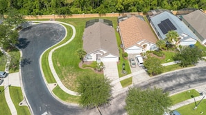 A residential area with houses, a curved driveway, and a street. - Magical 4BR Home w/ Pvt Pool/ Spa Near Disney 128 (Kissimmee)