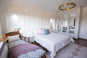 Une chambre à coucher avec un grand lit, une armoire et un miroir.