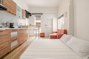 A compact living space with a kitchenette, a sofa, and a small table. - Moon house Modern Design, Comfortable & Elegant. (Cali)