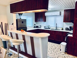 A modern kitchen with a central island, bar stools, a built-in oven, and a microwave. - Fabulous 3-bedroom house with AC in charming Savaneta (Savaneta)