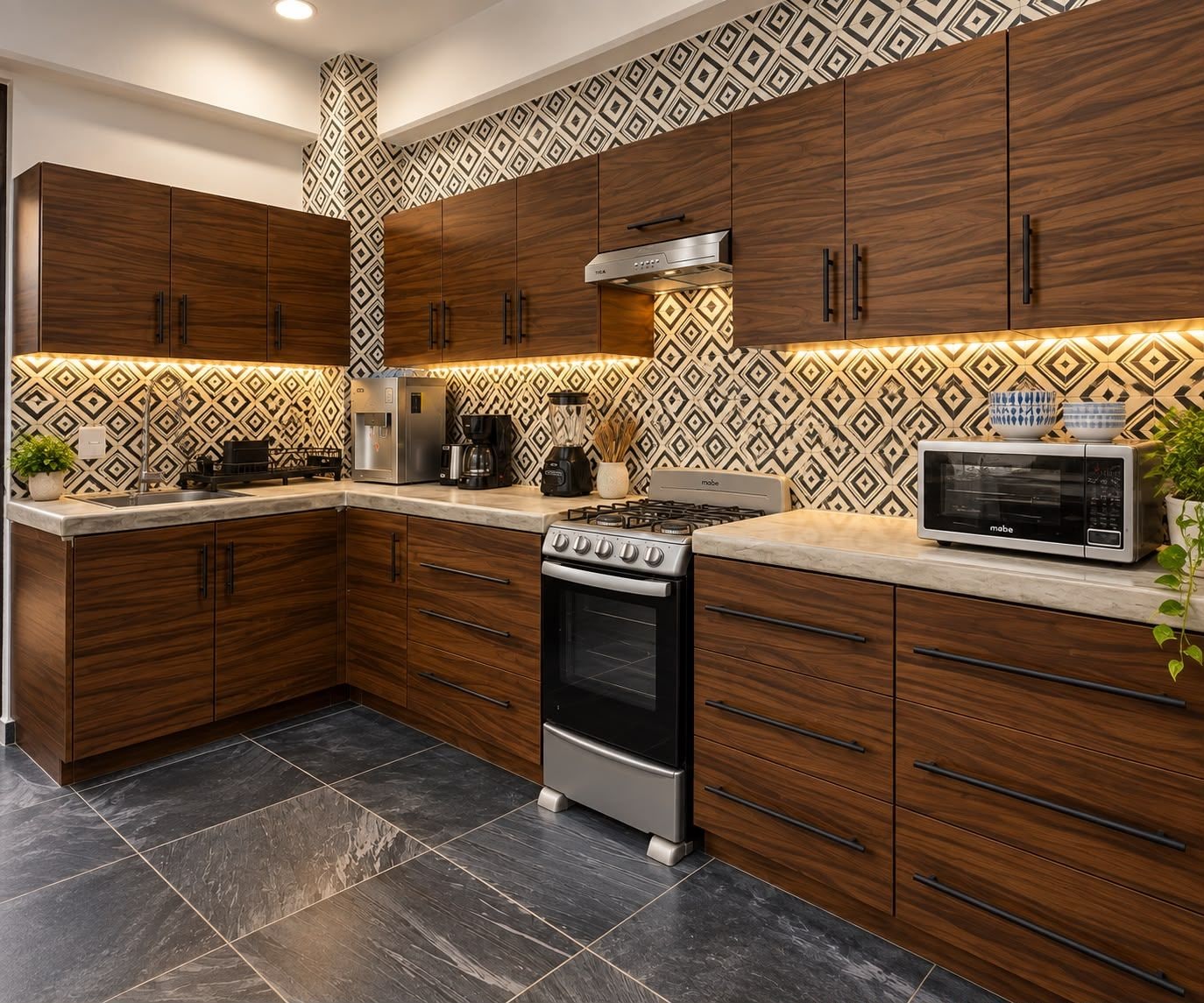 Una cocina moderna con armarios de madera oscura, estufa a gas, microondas y un salpicadero decorativo.