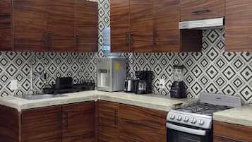 Una cocina moderna con armarios de madera oscura, estufa integrada y un salpicadero con diseño.