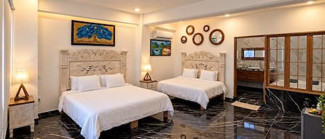 Habitación de hotel con dos camas, piso de mármol y obras de arte en las paredes.