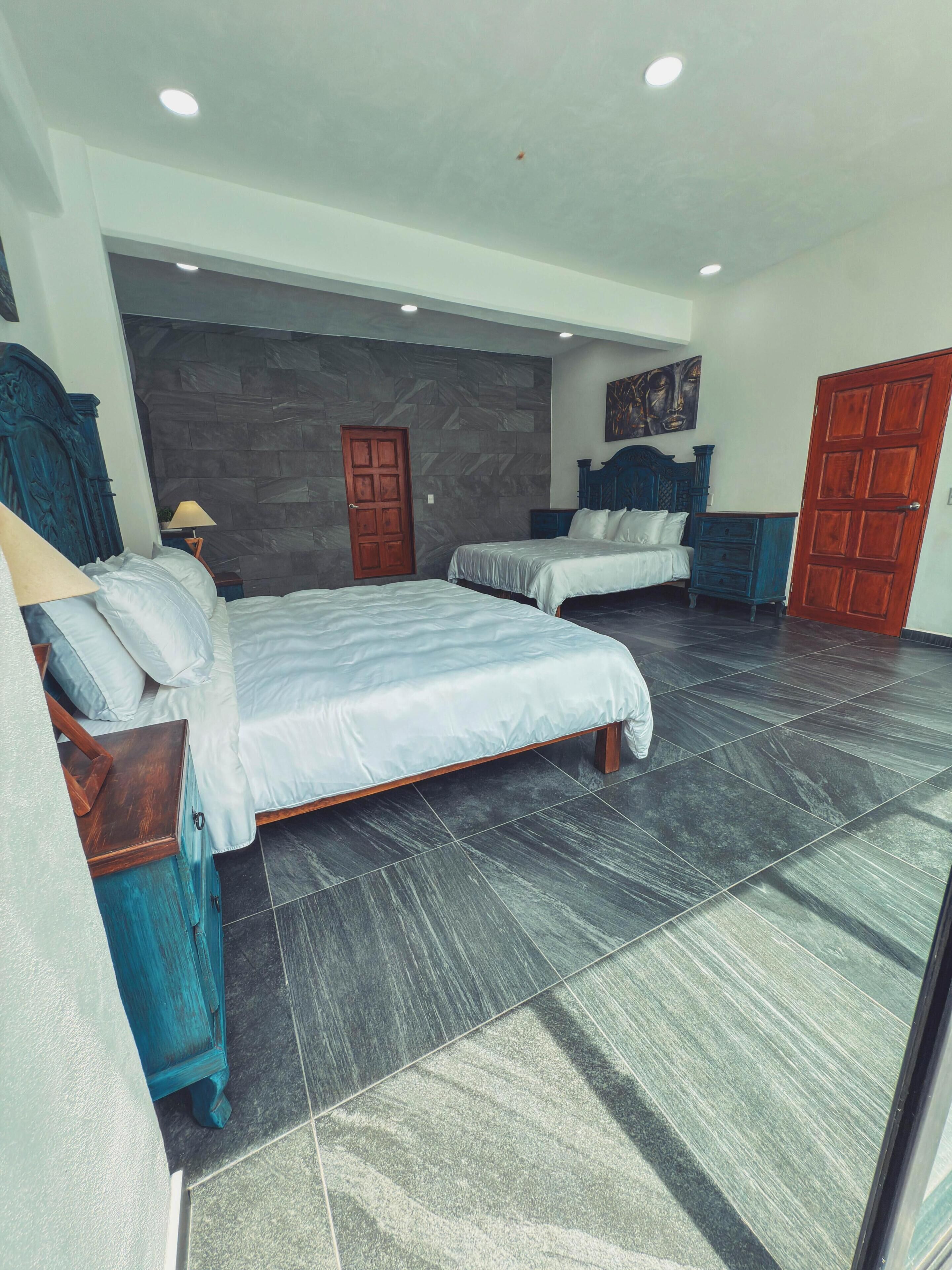 A bedroom with two beds, a wardrobe, and a door.