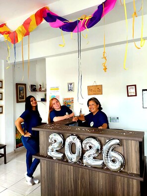 En reception med en ballondekoration med '2026', indrammede billeder på væggen og et farverigt banner.