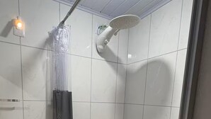 A small, tiled bathroom with a shower, toilet, and a glass basin. - Studio 5 | Vila Granados (Embu das Artes)