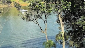 Ein ruhiger See mit einer Anlegestelle und Bäumen.