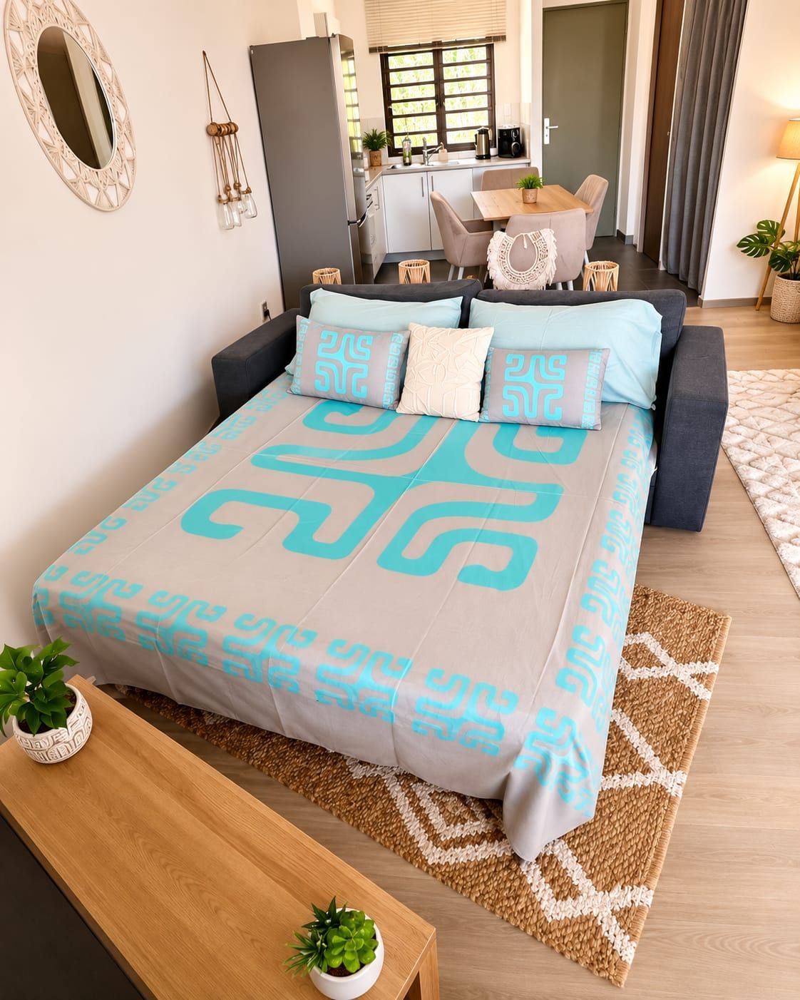 A modern bedroom with a bed, bedside tables, a mirror, and a view of the dining area.