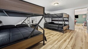 A compact room with bunk beds, a wooden floor, and a ceiling light. - River Bend Reserve (Frankfort)