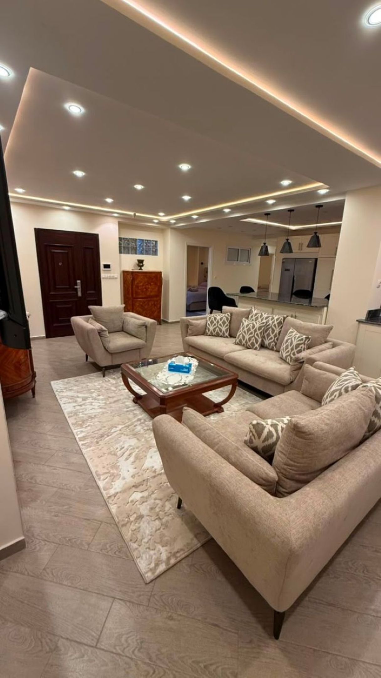 Una sala de estar moderna con un conjunto de sofás, una mesa de centro y una alfombra.