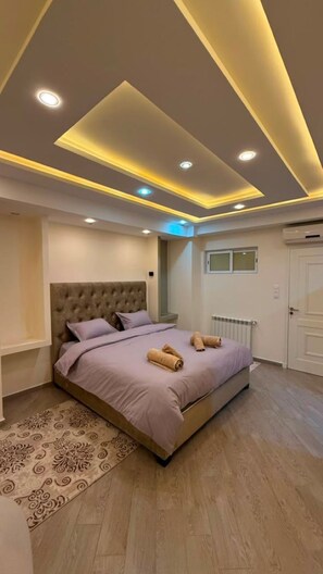 A bedroom with a large bed, a nightstand, a radiator, and a door. - Élégance à Kouba – 3 chambres, suite & garage. (Kouba)