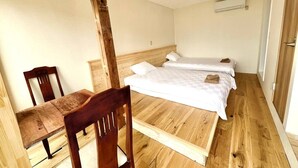 A room with two beds, a wooden chair, and a wooden table. - umi no tonari hotel & cafe (Kyotango / Tango/ Taiza)