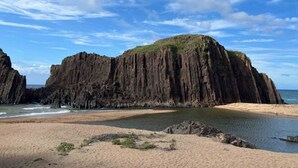 A coastal landscape with a prominent rock formation, a sandy beach, and calm waters. - umi no tonari hotel & cafe (Kyotango / Tango/ Taiza)