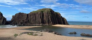 A coastal landscape with a prominent rock formation, a sandy beach, and calm waters. - umi no tonari hotel & cafe (Kyotango / Tango/ Taiza)