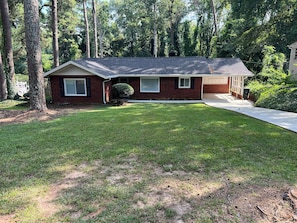 A single-story house with a front yard, a garage, and a small front porch. - Cozy family/pet friendly, 3 BDR pool home, 20 mins from downtown Atlanta. (Atlanta)