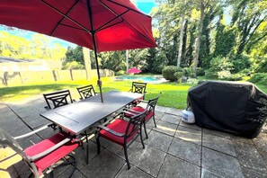 A patio with a table and chairs, a grill, and a pool in the background. - Cozy family/pet friendly, 3 BDR pool home, 20 mins from downtown Atlanta. (Atlanta)