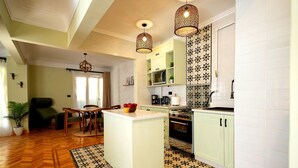 Una cucina moderna con isola centrale, luci a sospensione e piastrelle a motivi.