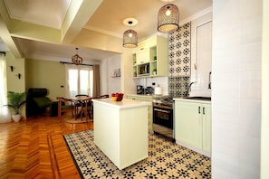 A modern kitchen with a central island, pendant lights, and patterned floor tiles. - Heliopolis 2 Bedrooms Apartments with Huge Patio - 10 Minutes to Airport (Cairo Governorate)