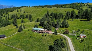 Une propriété rurale comprenant une grande maison entourée d’un terrain clos, un petit bâtiment et un chemin sinueux.