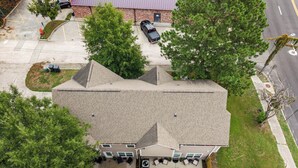 Ein Wohngebäude mit Satteldach, einer Veranda mit Sitzgelegenheit und einer Garage.