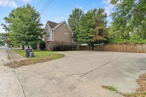 A residential driveway leading to a two-story house with a front yard and a wooden fence. - 2BR Home Near Augusta National & Medical District (Augusta)