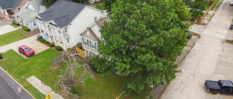 A residential area with houses, a parking lot, and a large tree.