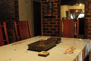 Una mesa de comedor con dos cofres de madera y una pila de cartas.