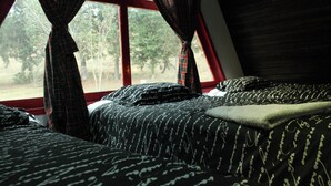 Ein Schlafzimmer mit einem Bett, einem Fenster und Vorhängen.