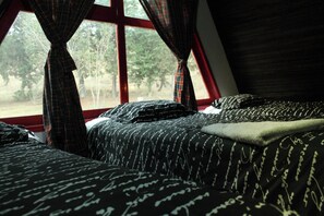 Un dormitorio con cama, ventana y cortinas.