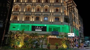 A multi-story building with a sign reading 'Collection' and a 'Company-Served' logo. - Classic Iubit Hotel (Kolkata)