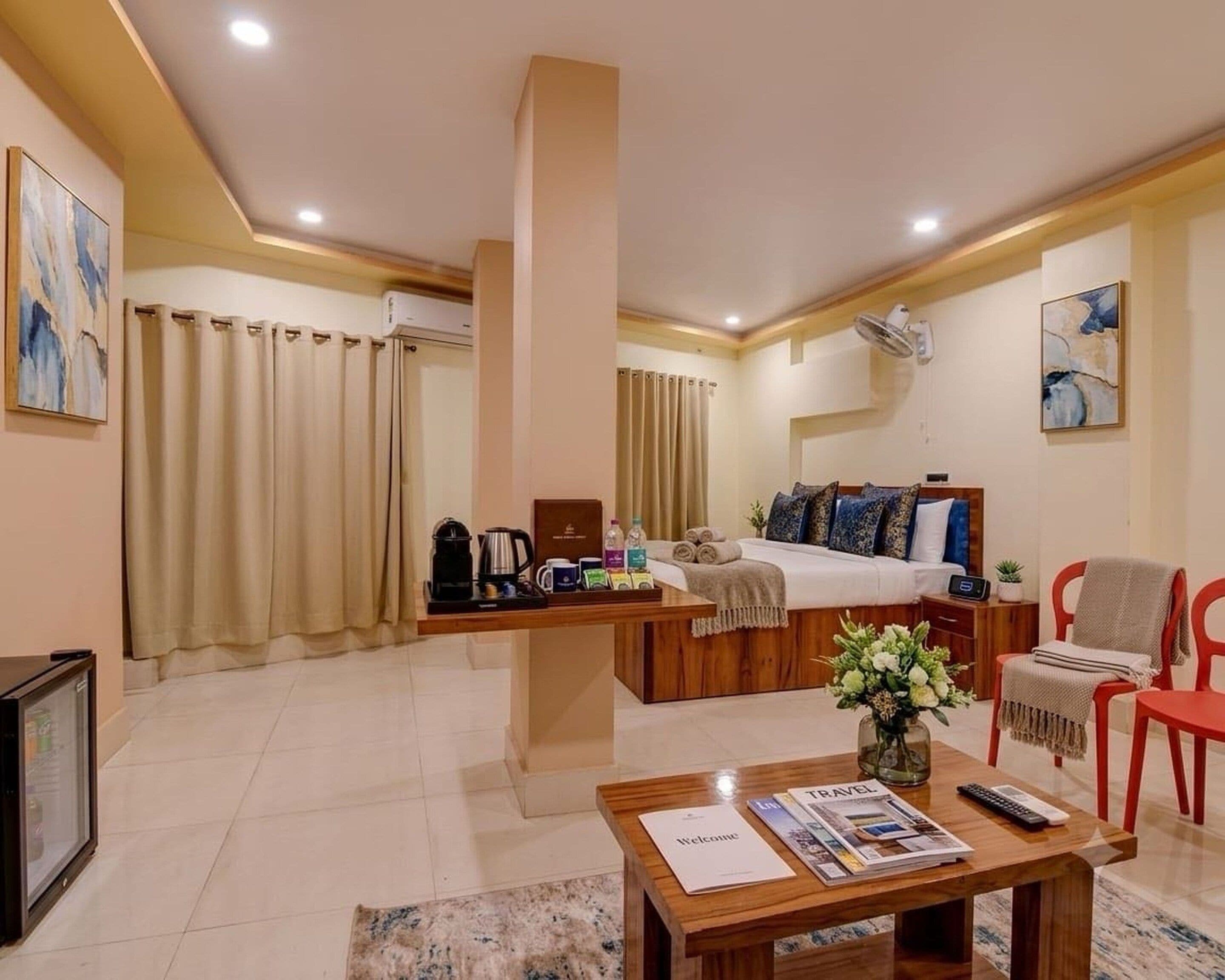 A hotel room with a bed, a desk, a chair, a TV, and a coffee maker.